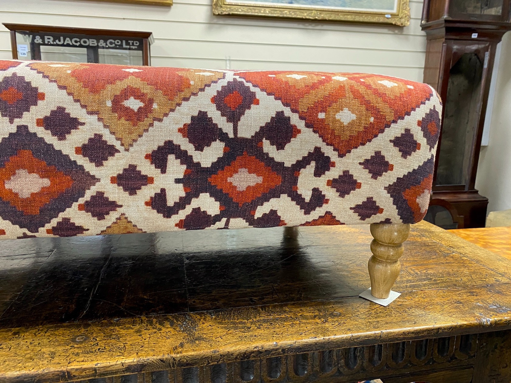 A large contemporary rectangular footstool upholstered in Kilim style fabric on turned beech feet, length 125cm, depth 74cm, height 39cm